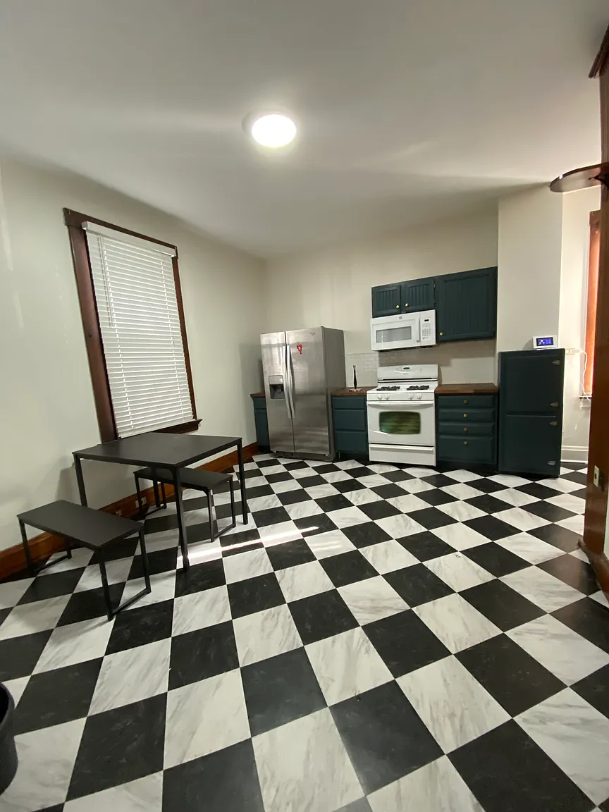 Kitchen and dining area with a window, table, and stainless steel refrigerator
